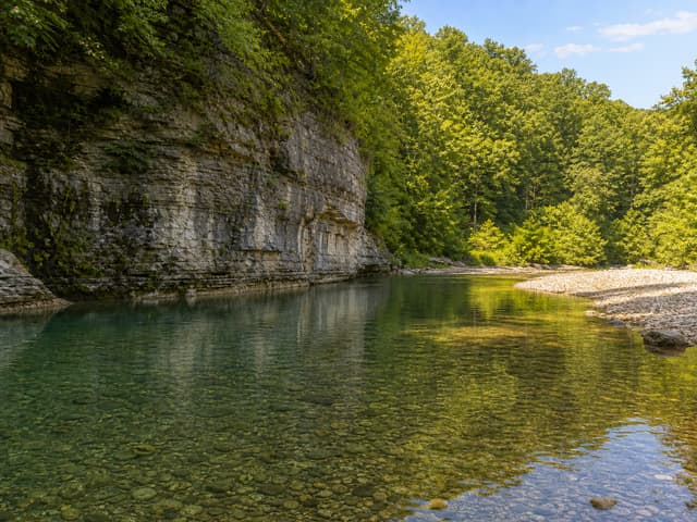 Editorial image of a granite mountain creek pool with smooth boulders