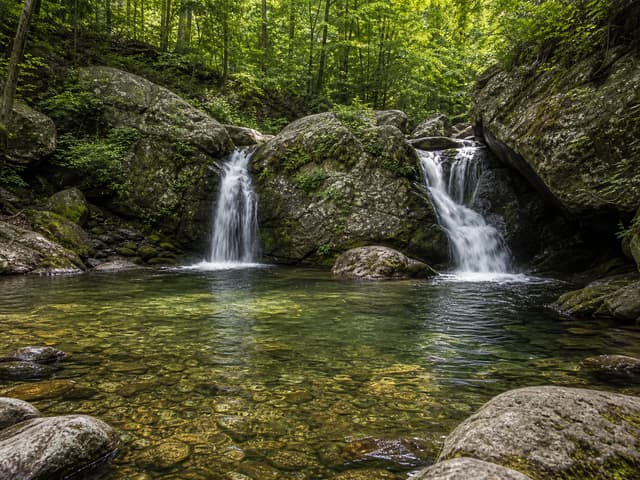 Editorial image of a calm limestone gorge pool viewed from shore