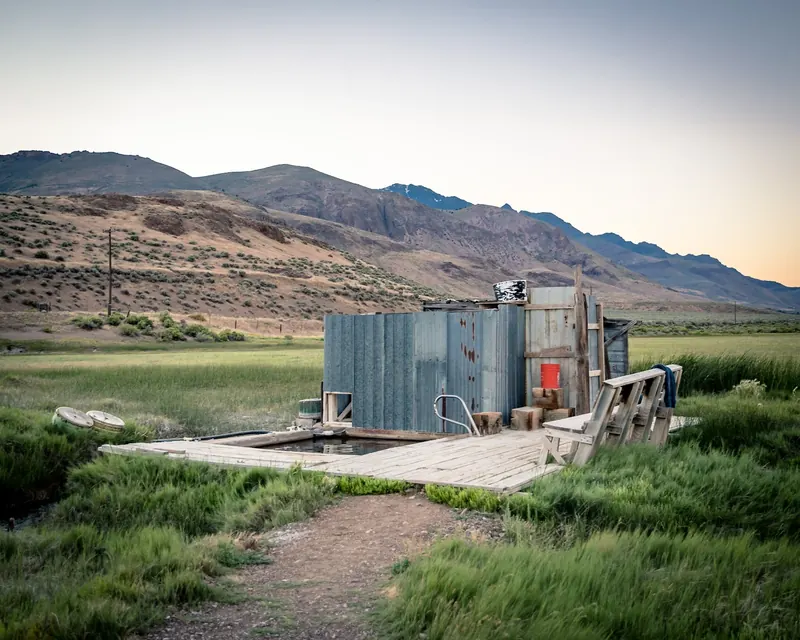 Rustic bathhouse and wooden pool deck at Alvord Hot Springs beneath Steens Mountain
