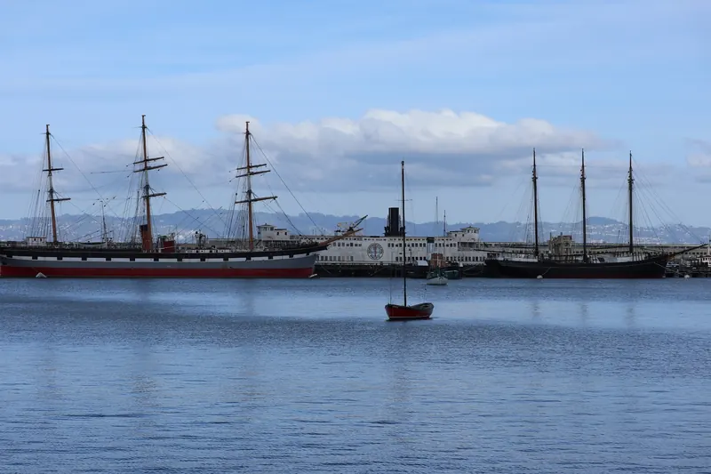 Past view of historic ships moored across Aquatic Park Cove, not the current pier arrangement