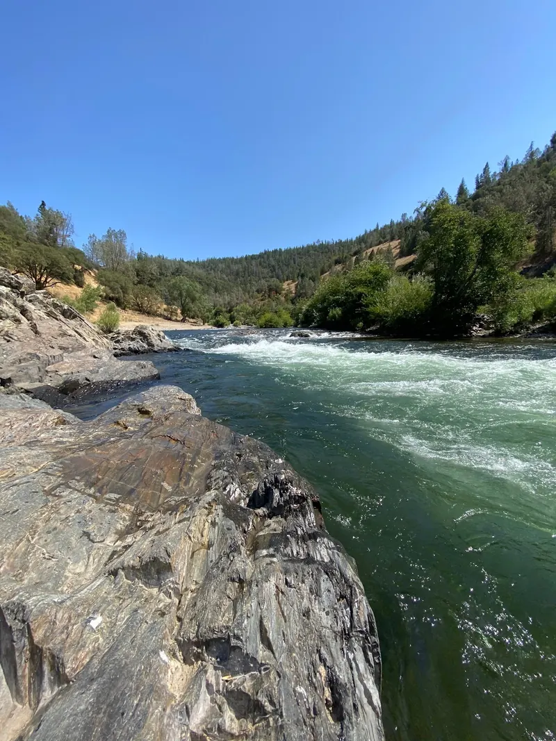 Whitewater rapids beside rocky banks in the Auburn American River region