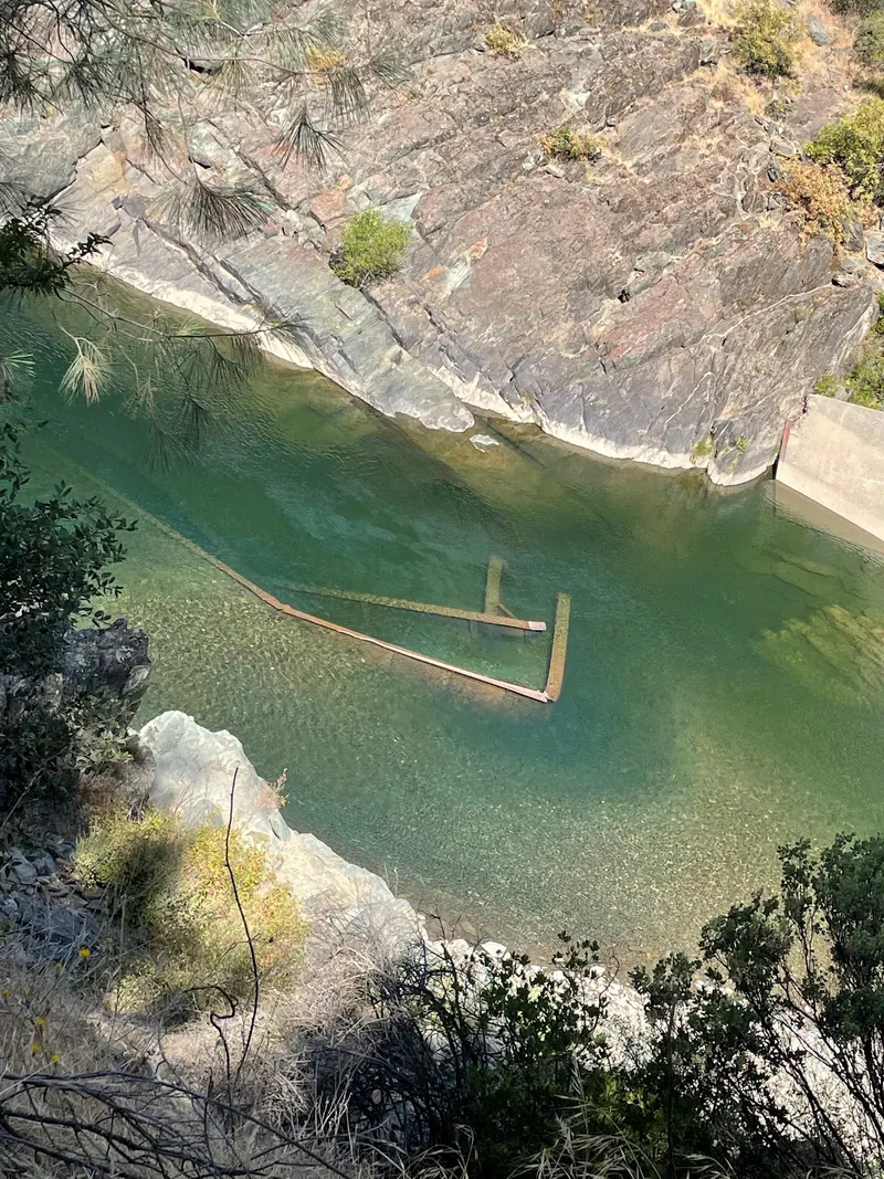 Submerged material visible beside a rock wall in the Auburn American River collection; historical detail, not evidence of safe depth or an entry point