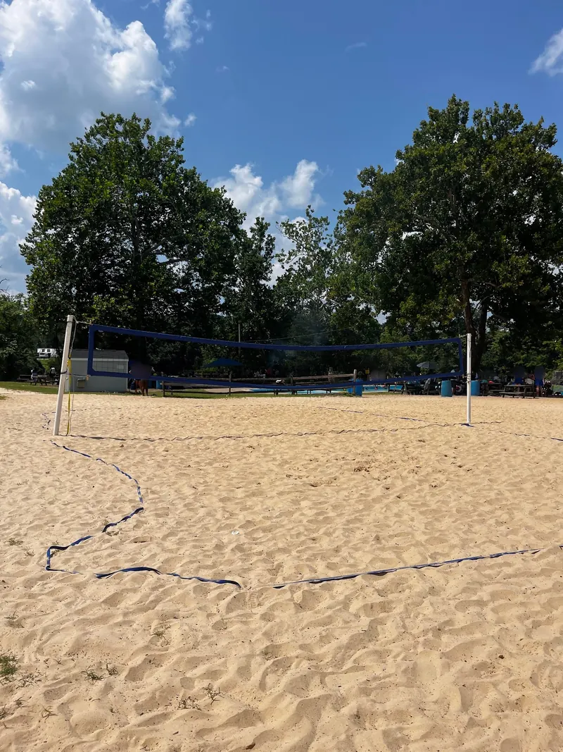 Sand volleyball court beside picnic tables at Beaver Dam Swimming Club
