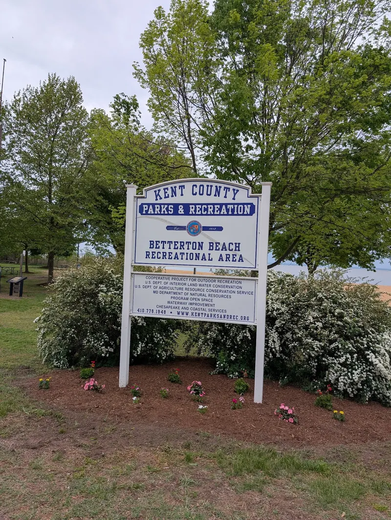 Betterton Beach Recreational Area entrance sign surrounded by flowering shrubs