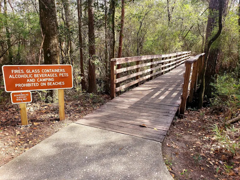 Wooden boardwalk and beach rules sign at Blackwater River State Park