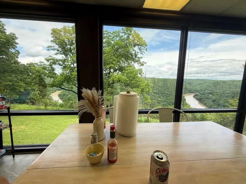 Dining table beside windows overlooking the river in the Buffalo Point concession collection; historical dining context, not current service availability