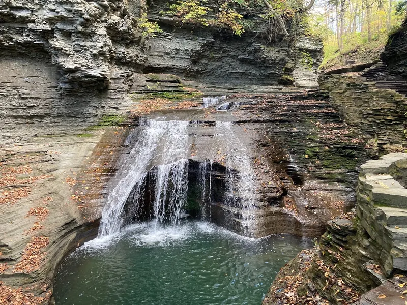 Gorge cascade beside stone trail steps at Buttermilk Falls State Park, not a designated swimming area