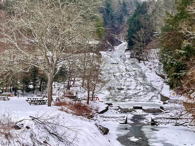 Snow and ice around the main falls and picnic area at Buttermilk Falls State Park in winter