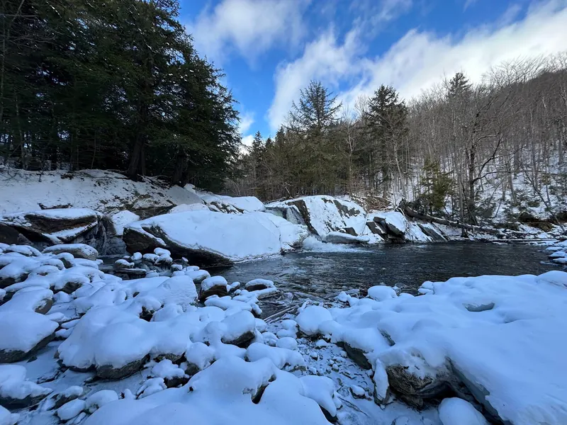 Snow-covered rocks around Buttermilk Falls in Ludlow, Vermont, during winter