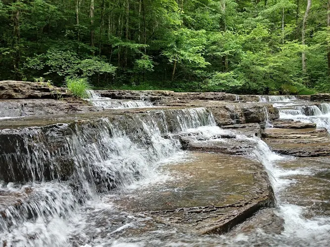 Water cascading over layered rock in Camp Creek State Park and Forest; park scenery, not an independently identified waterfall entry