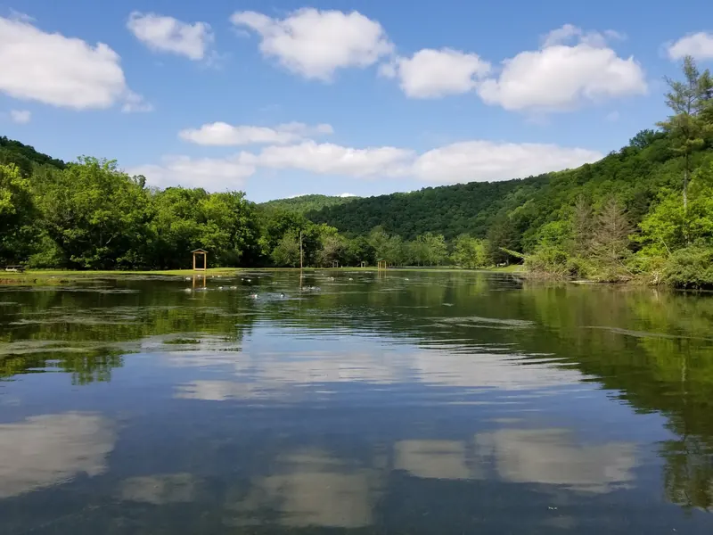 Pond and wooded hills at Cedar Creek State Park, not the unverified creek swimming entry
