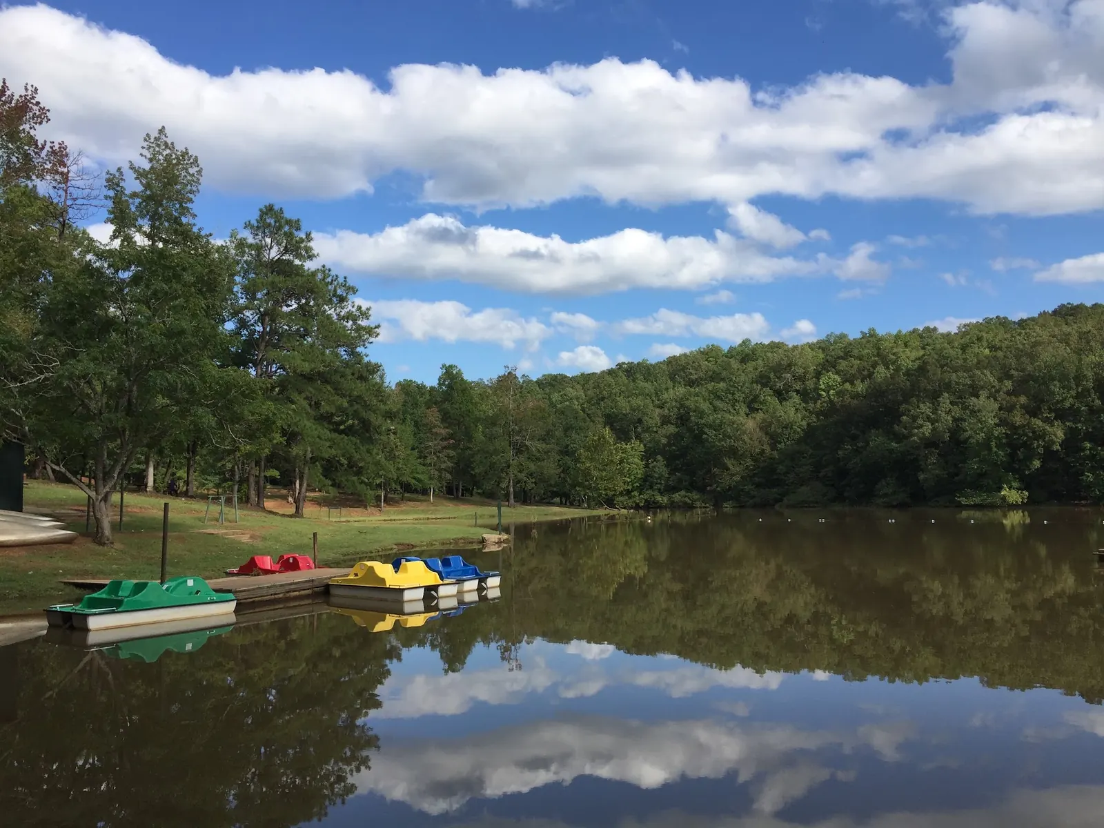Colorful pedal boats moored beside the wooded lake at Chewacla State Park