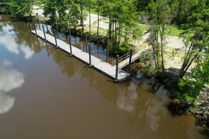 Dock beside wooded creek banks in the Chickasabogue Park photo set; not the designated swimming beach