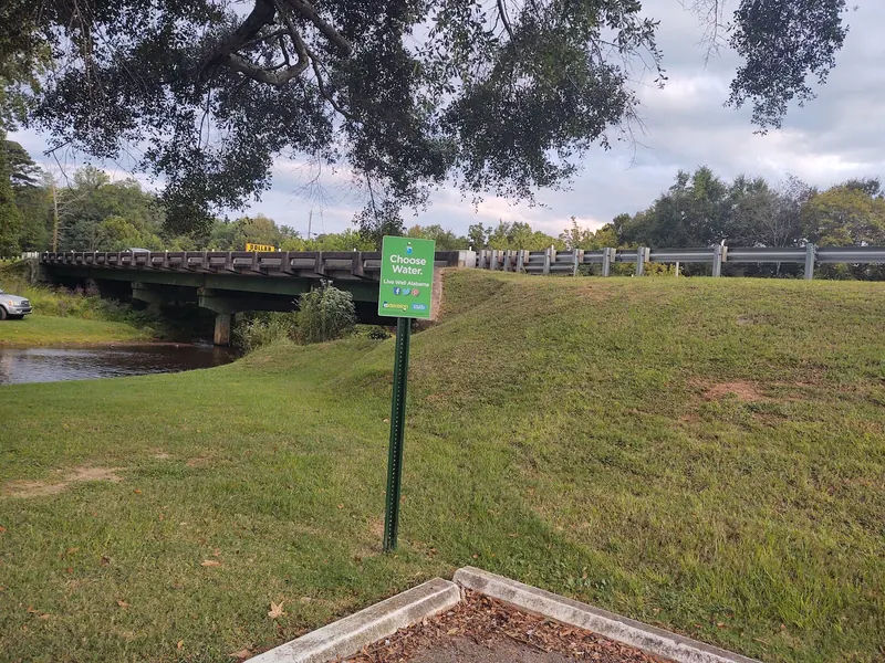 Grassy bank and Choose Water drinking-water campaign sign at Coldwater Creek; not a creek water-test result