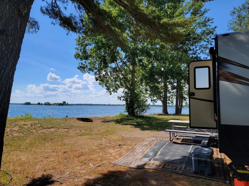 Waterfront campsite with a picnic table and RV at Coles Creek State Park, not the designated swimming beach