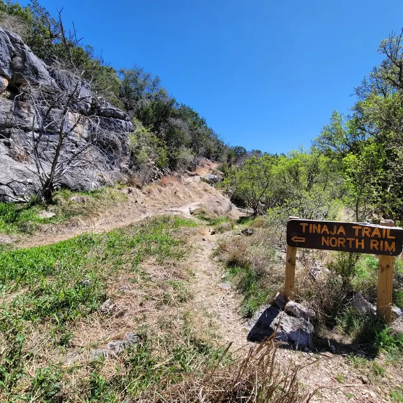 Tinaja Trail North Rim sign beside a rocky hiking path at Colorado Bend State Park, not the Spicewood Springs swimming area