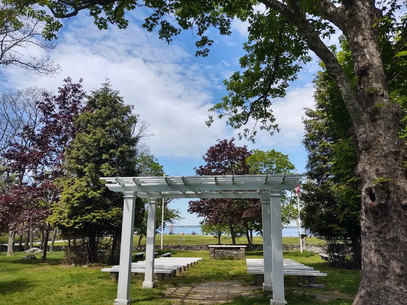 White pergola and benches at Colt State Park with Narragansett Bay beyond