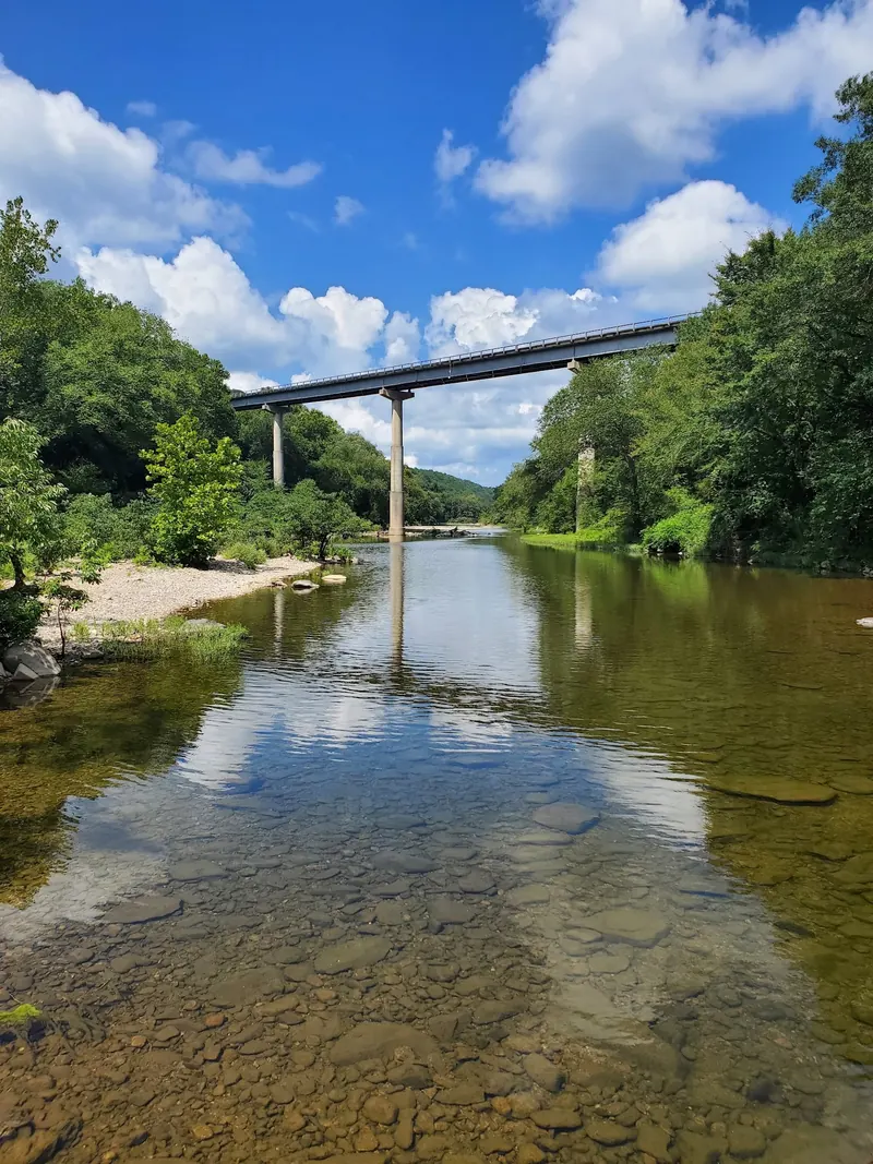 River beneath a highway bridge in Cossatot River State Park; park context, not a verified swimming entry