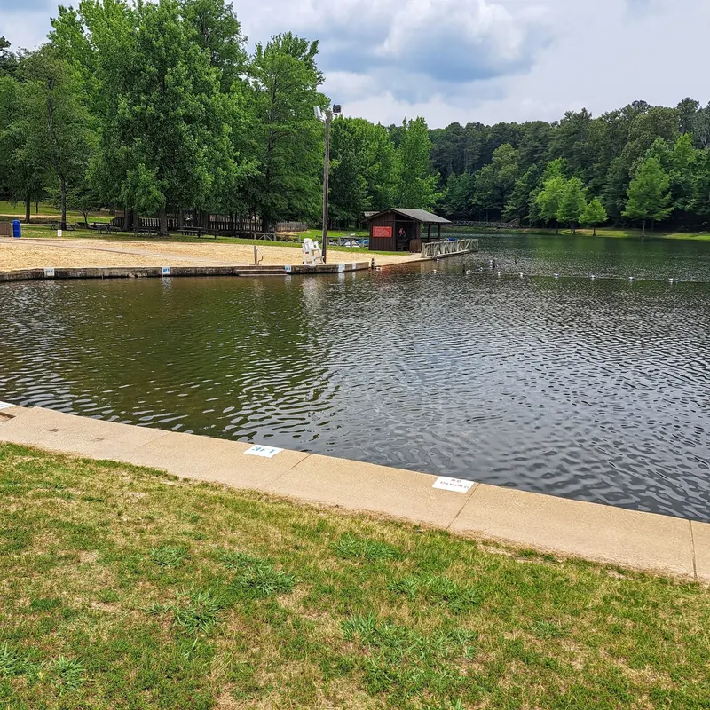 Marked swimming area with sandy shore and lifeguard chair at Crowley's Ridge State Park