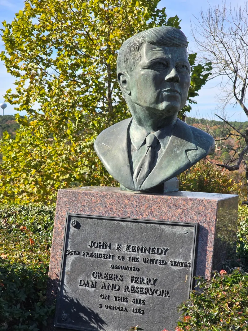 John F Kennedy bust above a plaque commemorating the 1963 Greers Ferry Dam and Reservoir dedication; regional landmark, not a swimming entrance