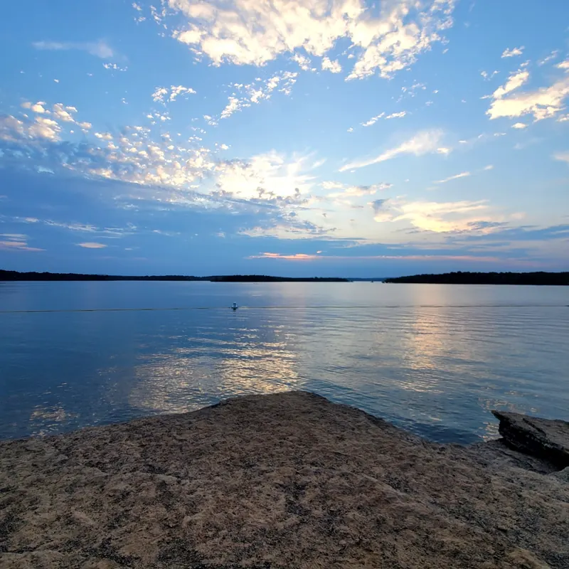 Evening sky reflected on Greers Ferry Lake from the rocky shore at Dam Site