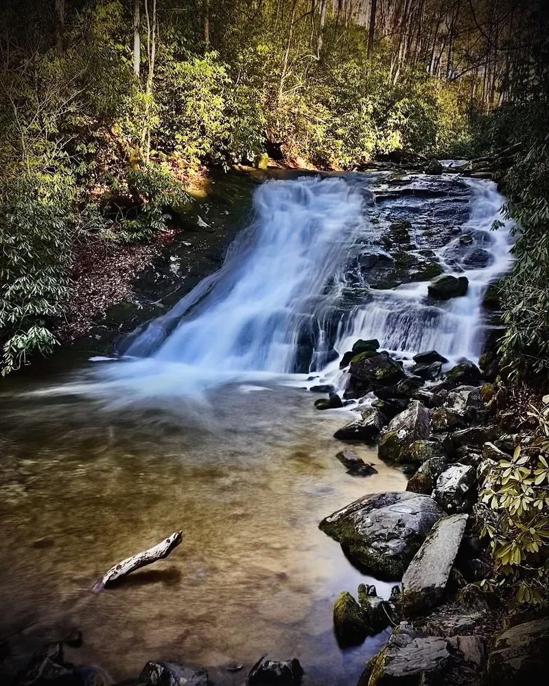 Cascade over dark rock ledges in the Deep Creek trail area, shown as waterfall scenery rather than a swimming entry