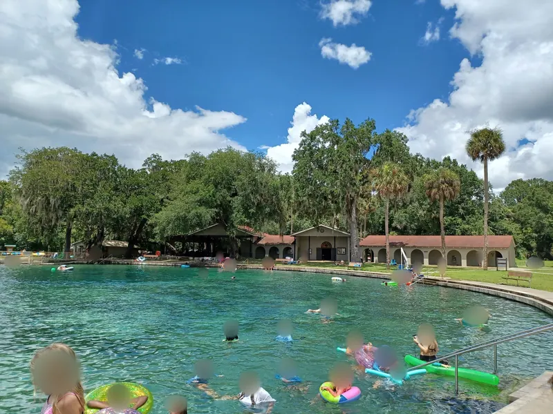 Spring swimming pool with entry handrails and surrounding park buildings at De Leon Springs State Park