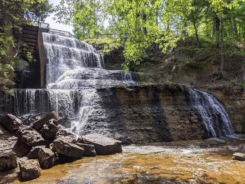 Dunn's Falls cascading over rocky ledges beside the mill water wheel, shown for scenery rather than swimming entry guidance