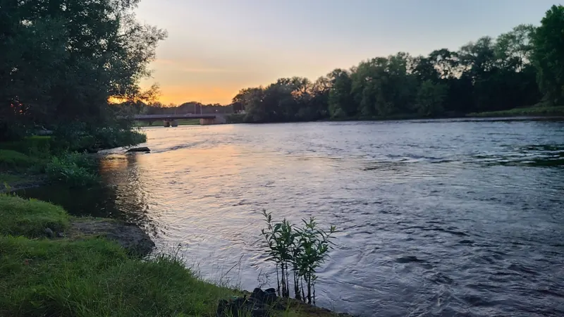 Evening view of the Oswegatchie River and nearby bridge from the Eel Weir shoreline