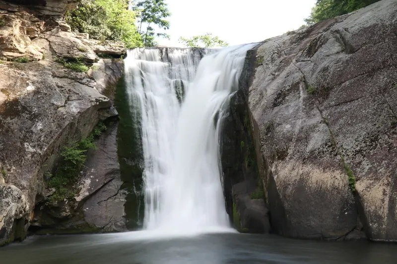 Elk River Falls descending between rock walls into its plunge pool, which visitors should not enter