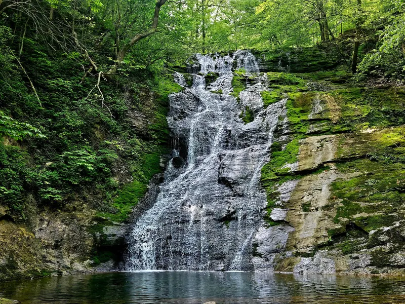 Water cascading over mossy rock into a pool at Elrod Falls in Hancock County, Tennessee