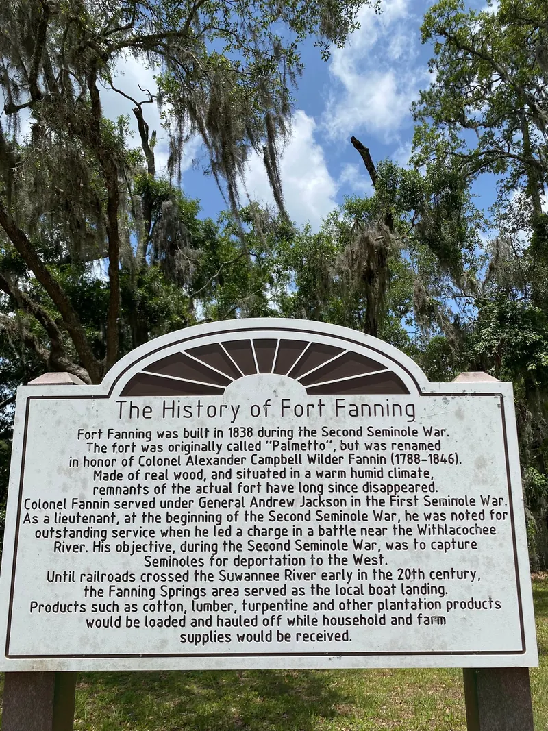 Fort Fanning history panel beneath moss-draped trees in the Fanning Springs collection; nearby heritage context, not a swimming entrance