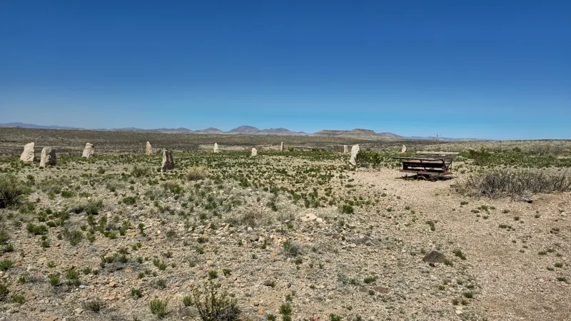 Upright stones and a picnic table across open desert terrain in the Faywood Hot Springs collection; historical grounds context, not a verified hiking route