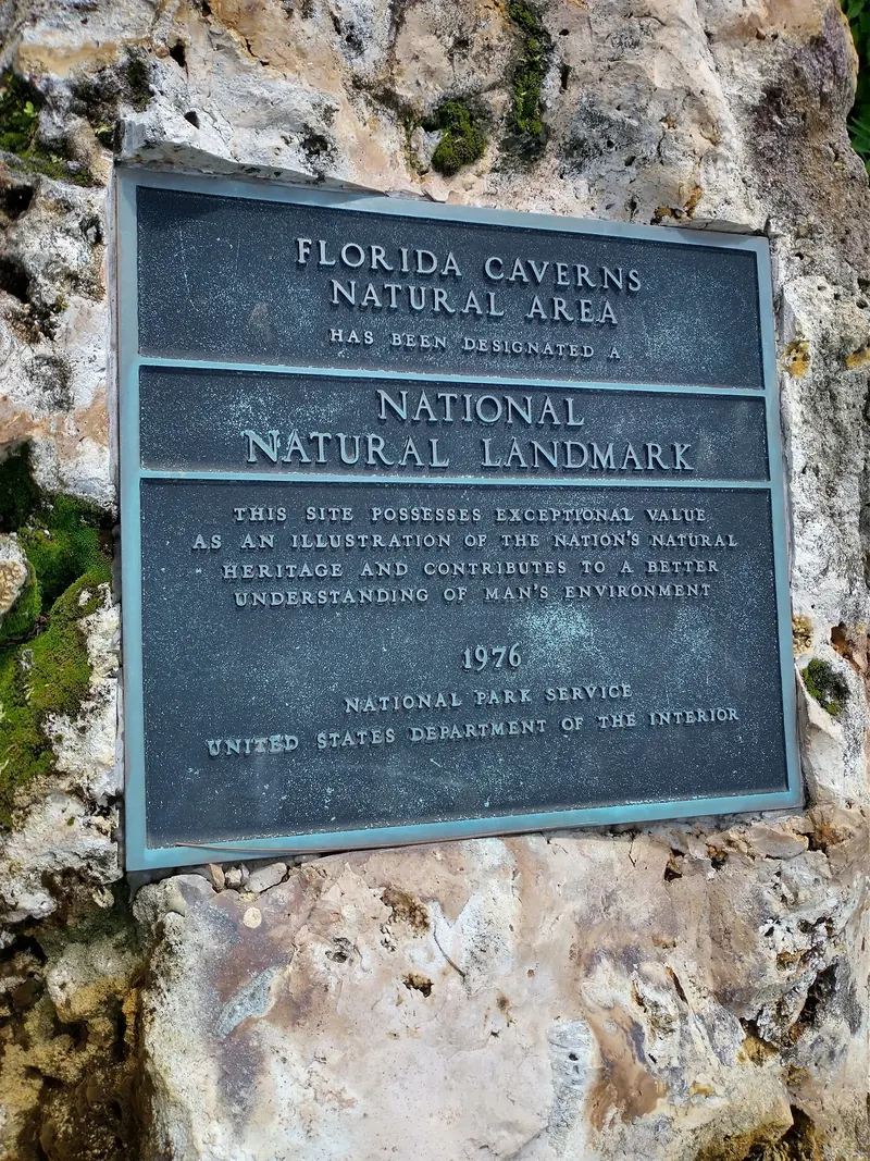 National Natural Landmark plaque for Florida Caverns Natural Area mounted on limestone; park context rather than a swimming-area photo