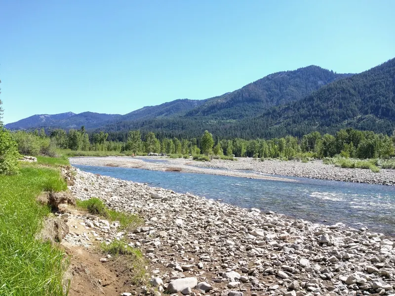River channel and broad gravel banks in the French Cabin Creek recreation area, with forested slopes beyond