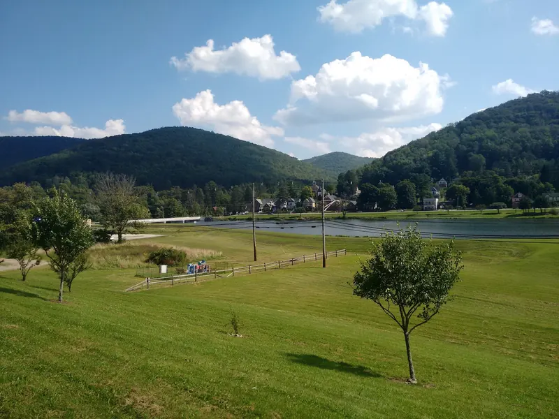Berger Lake and Galeton beneath wooded hills, with grassy parkland in the foreground