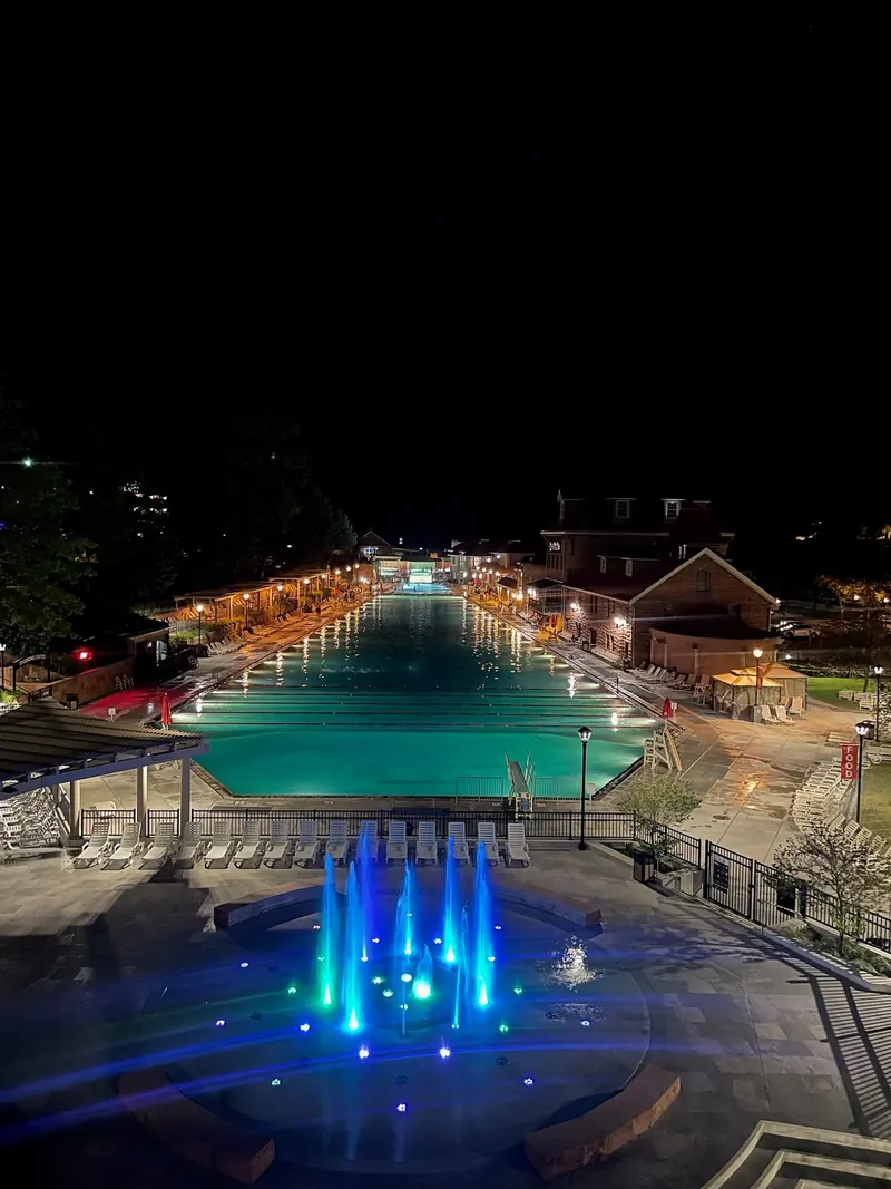 Historical illuminated Glenwood Hot Springs pool and blue-lit water features at night; not current opening hours