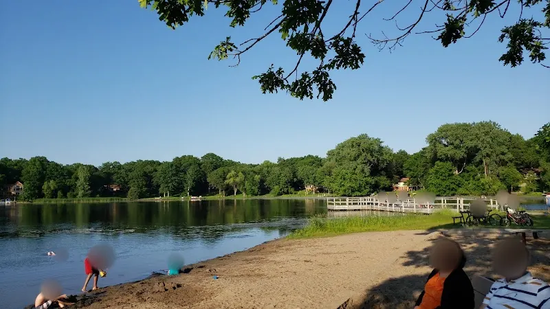 Golden Lake Park Beach with a sandy shoreline, lakeside pier and shaded seating