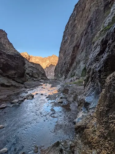 Wet rocky floor and steep canyon walls in the saved Goldstrike Hot Spring collection