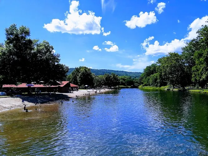 Historical overview of Green River Swimming and Recreation Area with sandy south-bank beach, red-roofed facilities and wooded banks; not current swimming access or water conditions