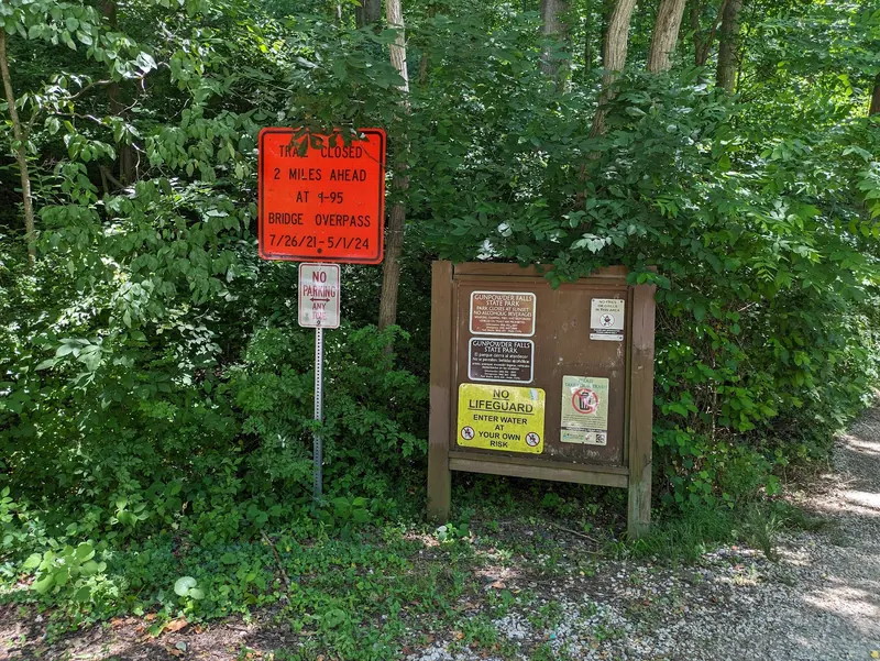 Historical Gunpowder Falls park rules board beside a trail closure notice dated 2021-2024