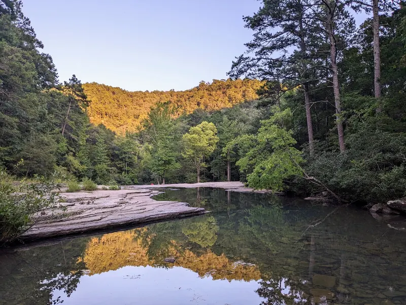 Creek pool and flat rock shelves in the Haw Creek Falls photo collection, reflecting wooded banks; depth and entry safety not established by the image