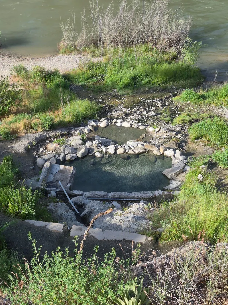 Steps descending toward rock-edged pools beside the river near Hot Springs Campground