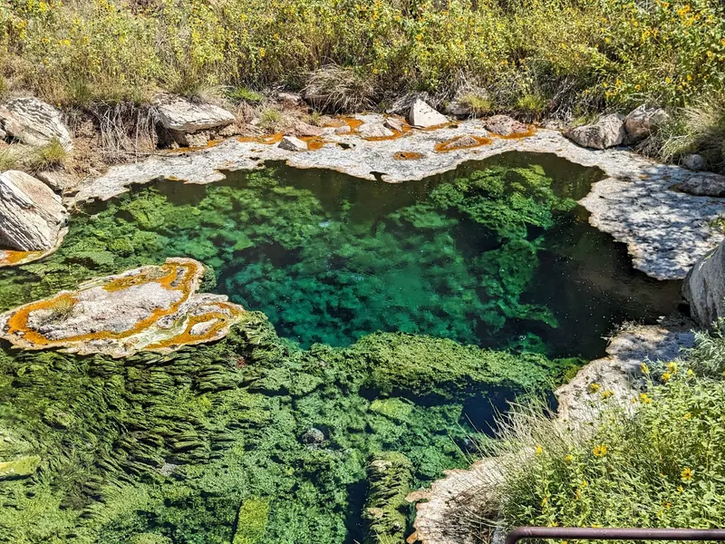 Mineral spring feature behind a viewing railing at Hot Springs State Park; not a bathing pool