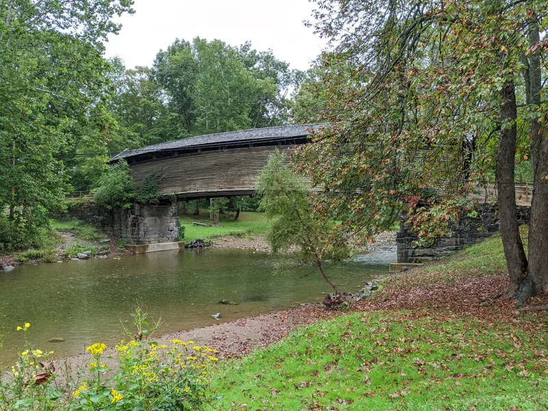 Side view of Humpback Bridge and its stone supports above the creek