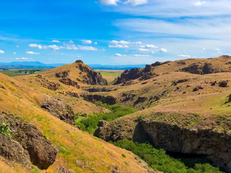 Historical dry hills and rocky canyon surrounding the green creek corridor at Jump Creek; not a verified overlook or access route