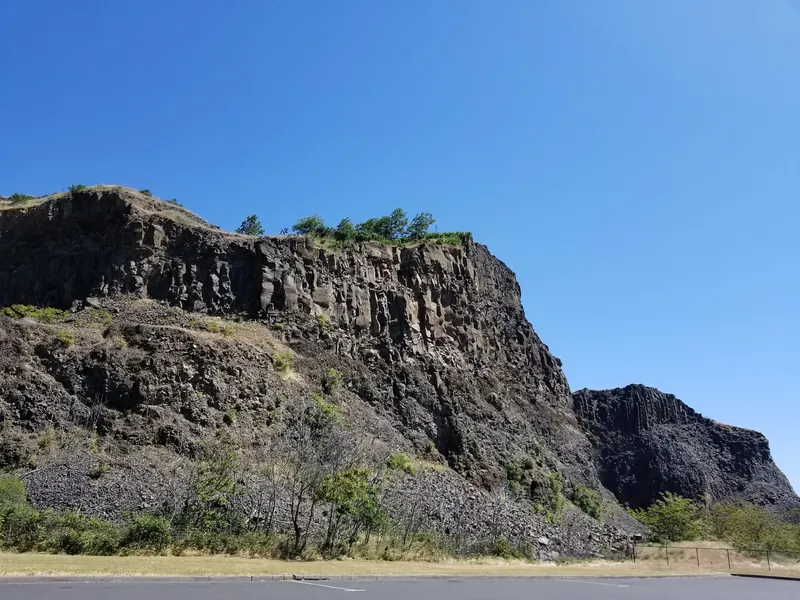 Columned basalt rock wall above an empty paved area in the Koberg photo collection