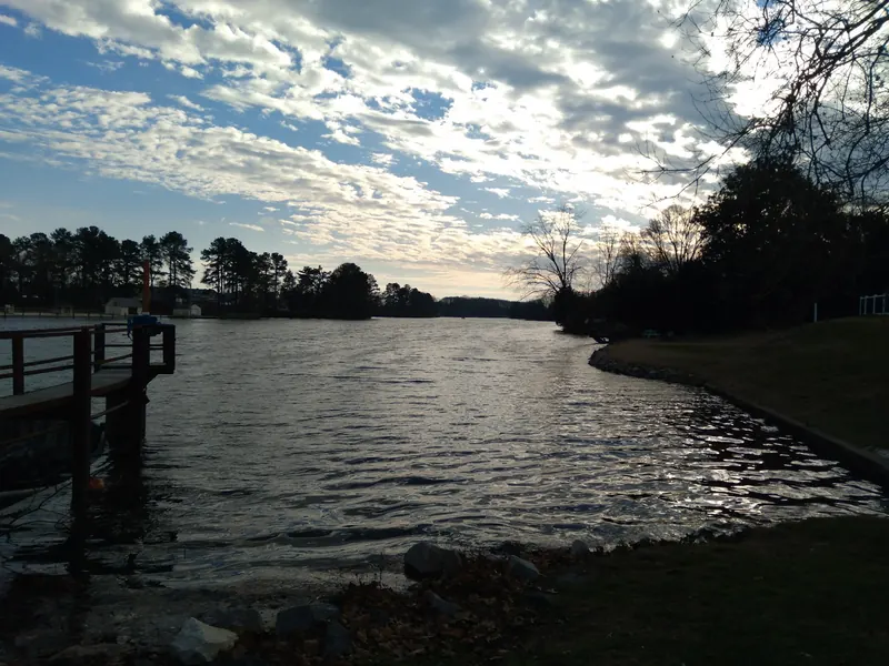 Lake Como shoreline and wooden lakeside railing beneath a cloudy sky in Smyrna