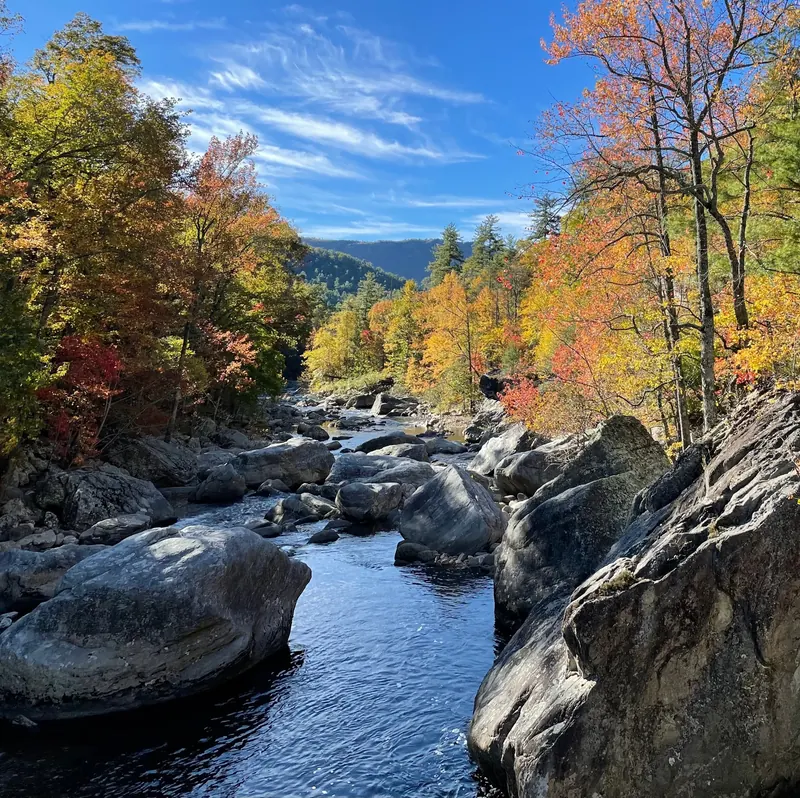 Boulder-lined waterway framed by autumn trees in a historical Linville Gorge area photo