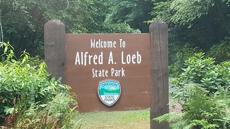 Wooden Alfred A. Loeb State Park welcome sign surrounded by green vegetation